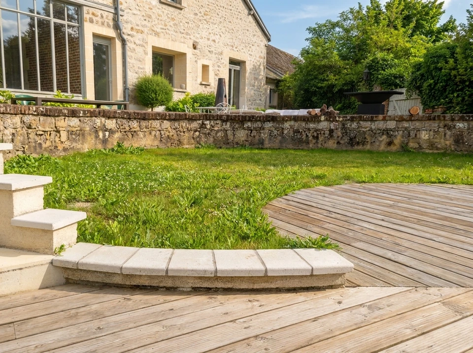 Jardin privatif entouré d'une haie taillée de type if ou thuya, haute et dense, formant une clôture végétale